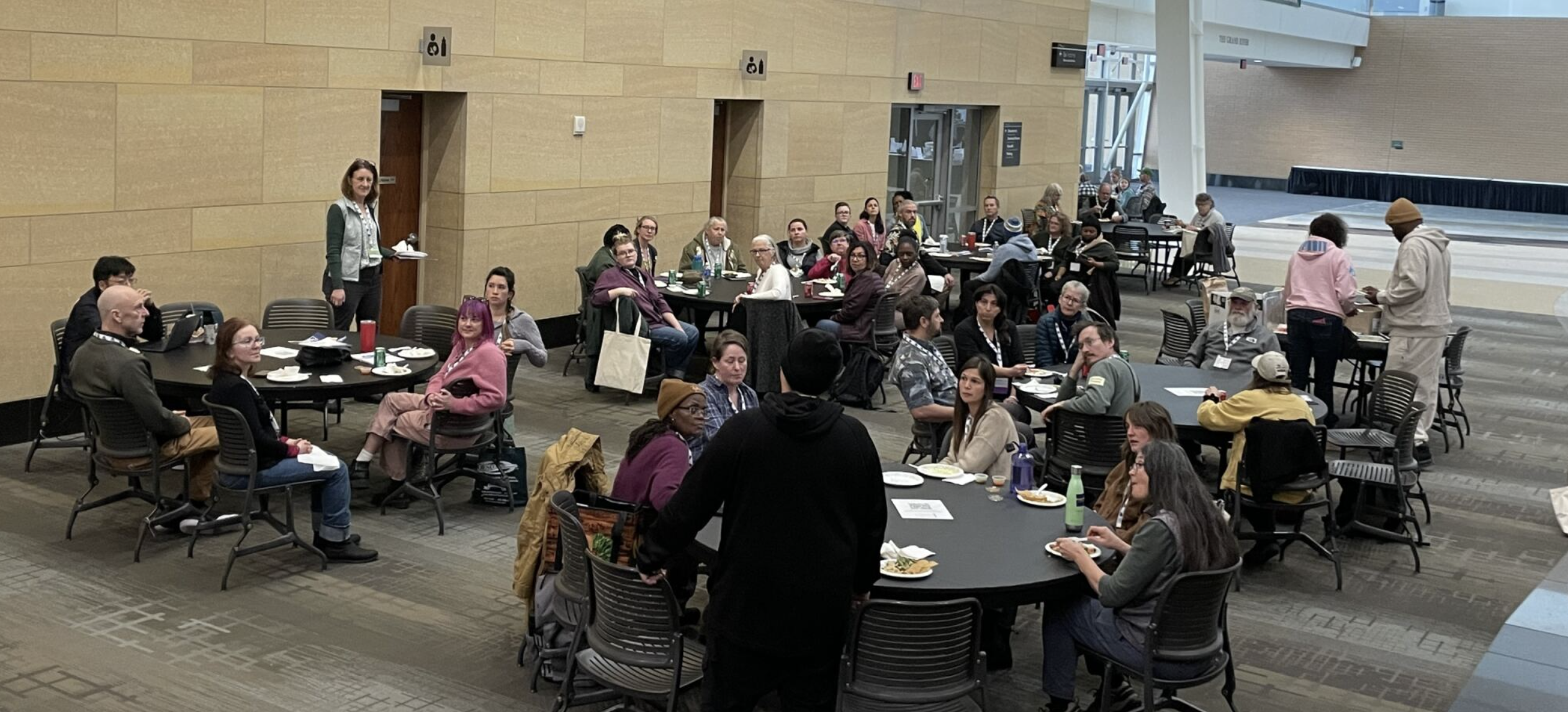 People seated at round tables eating lunch together at GLEXPO